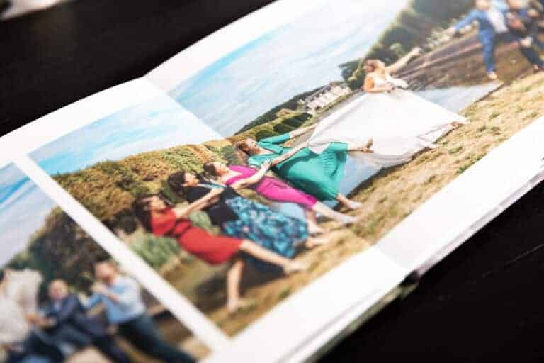 Album ouvert sur une photo de groupe d'invitées en robes colorées dans l'herbe