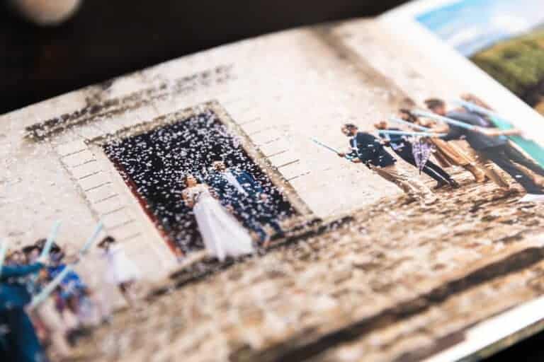 Album ouvert sur la sortie des mariés sous une pluie de confettis